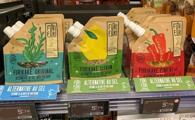 フランスのスーパーの棚に並ぶFURI FURIのふりかけ3種。オリジナル、レモン、チリのパウチが並び、棚札にALTERNATIVE AU SELの表示